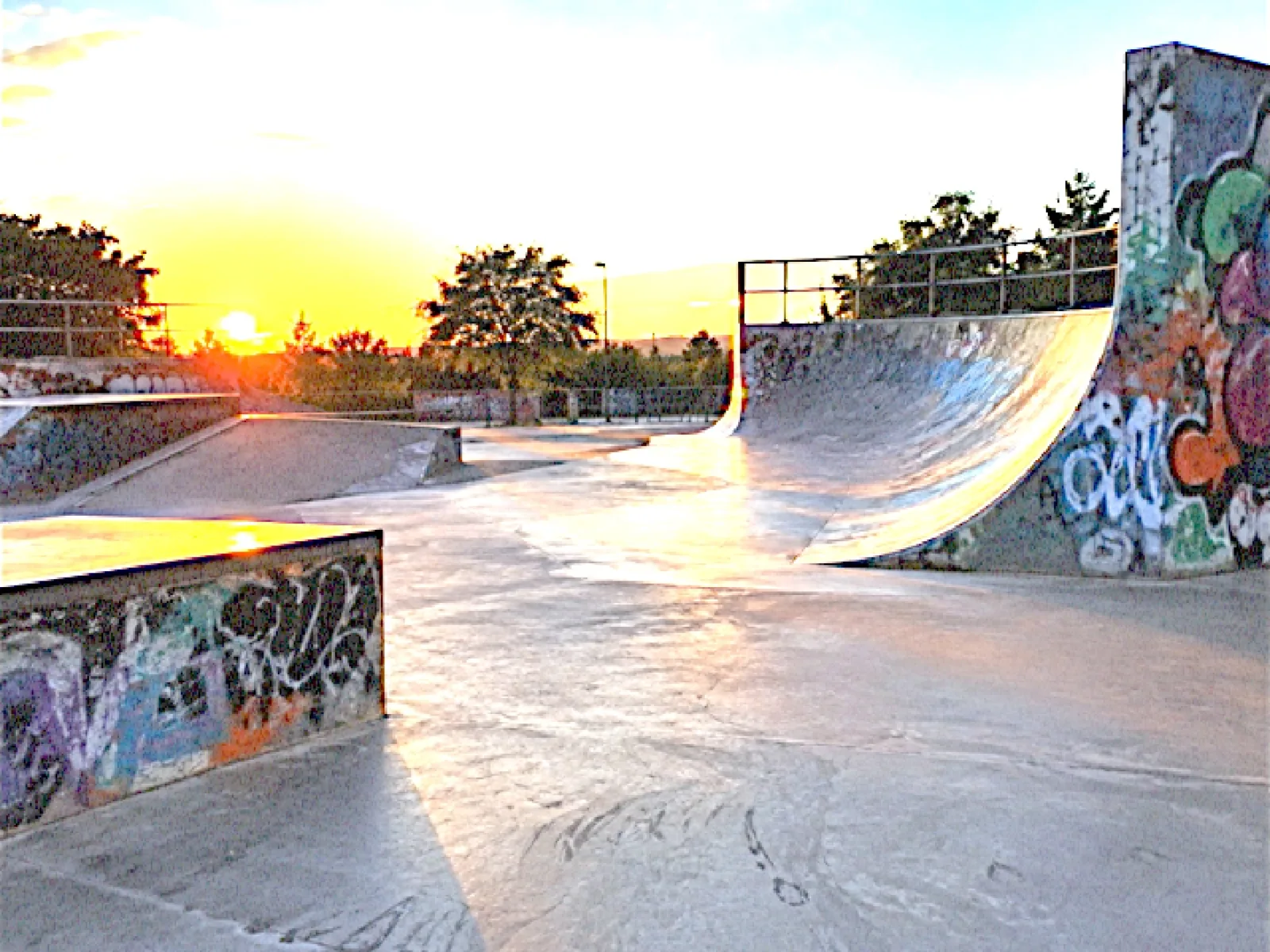 A skatepark with graffiti ramps at sunset, shot on the DV 05