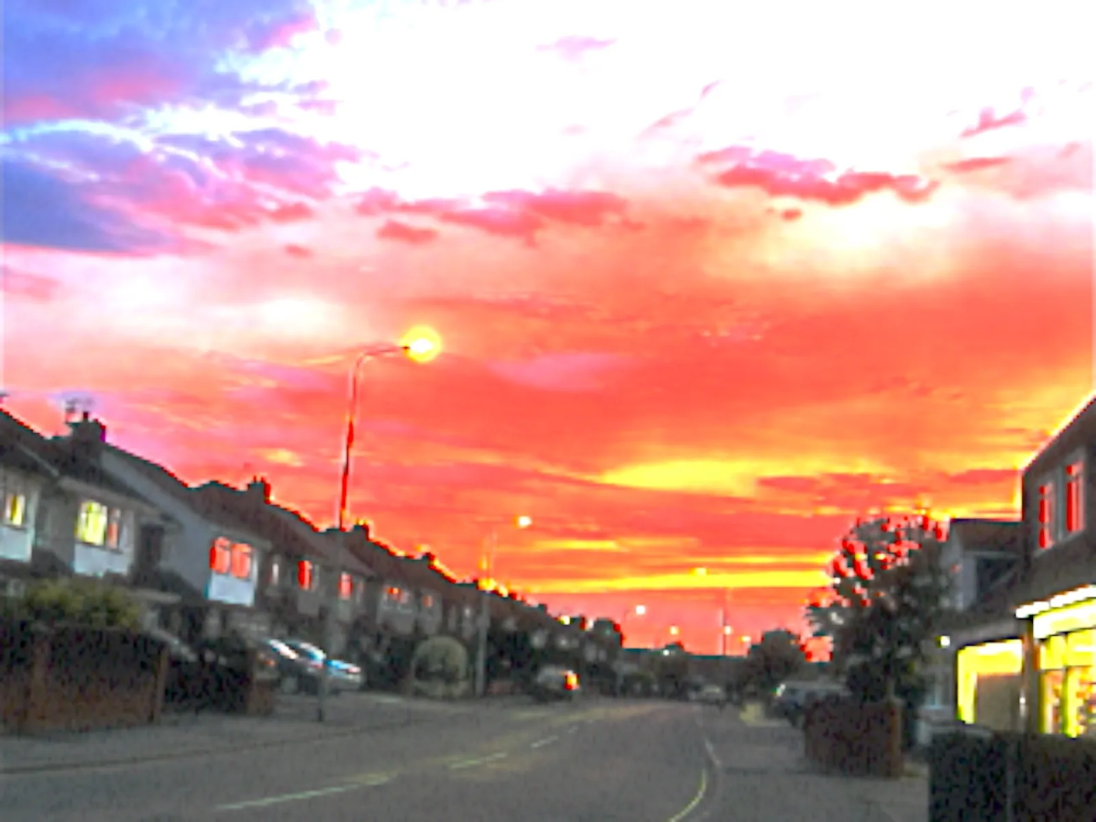 A pink sunset sky over a quiet suburban street, shot on the FLIP 06